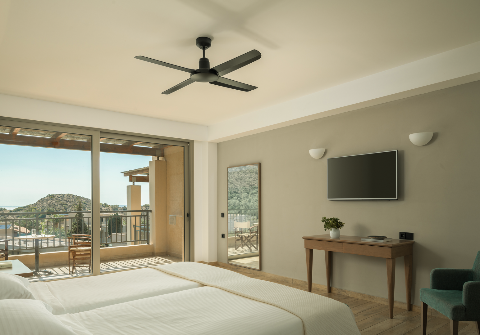 Helles Zimmer mit Doppelbett, Deckenventilator und Meerblick