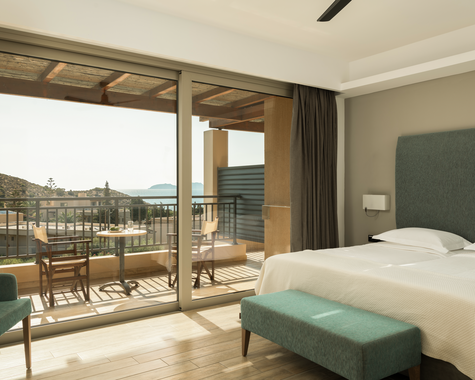Schlafzimmer mit Doppelbett, türkisem Kopfteil und Balkon