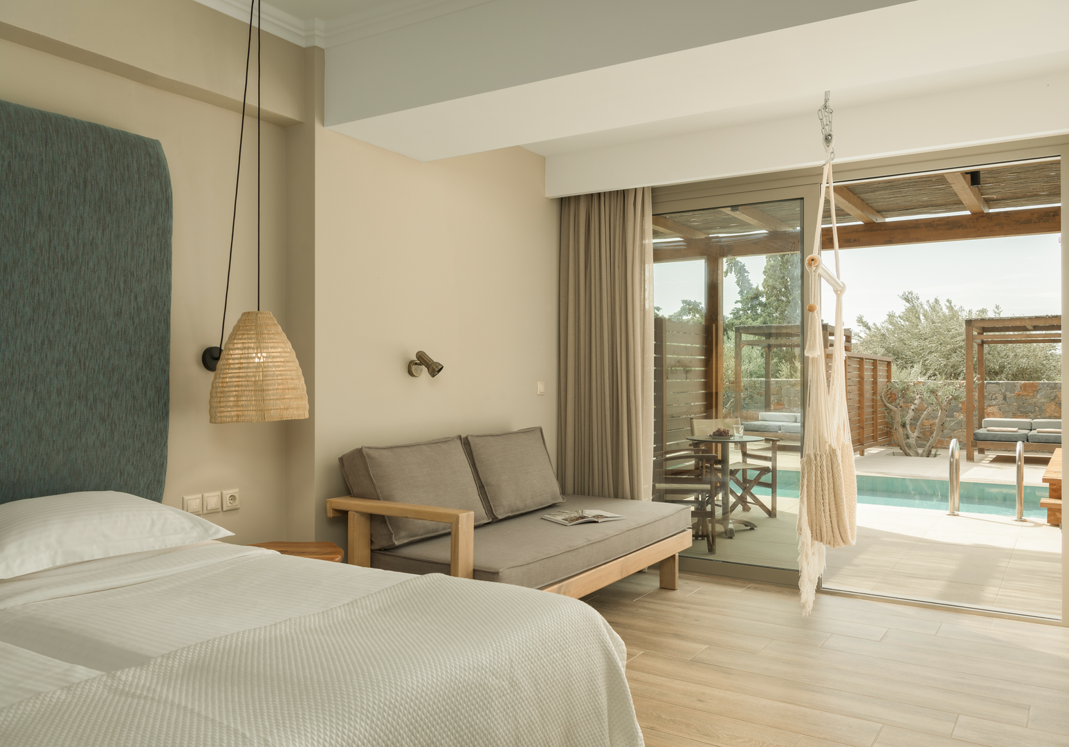 Schlafzimmer mit Doppelbett, Sofa und Poolblick