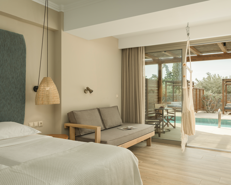 Schlafzimmer mit Doppelbett, Sofa und Poolblick