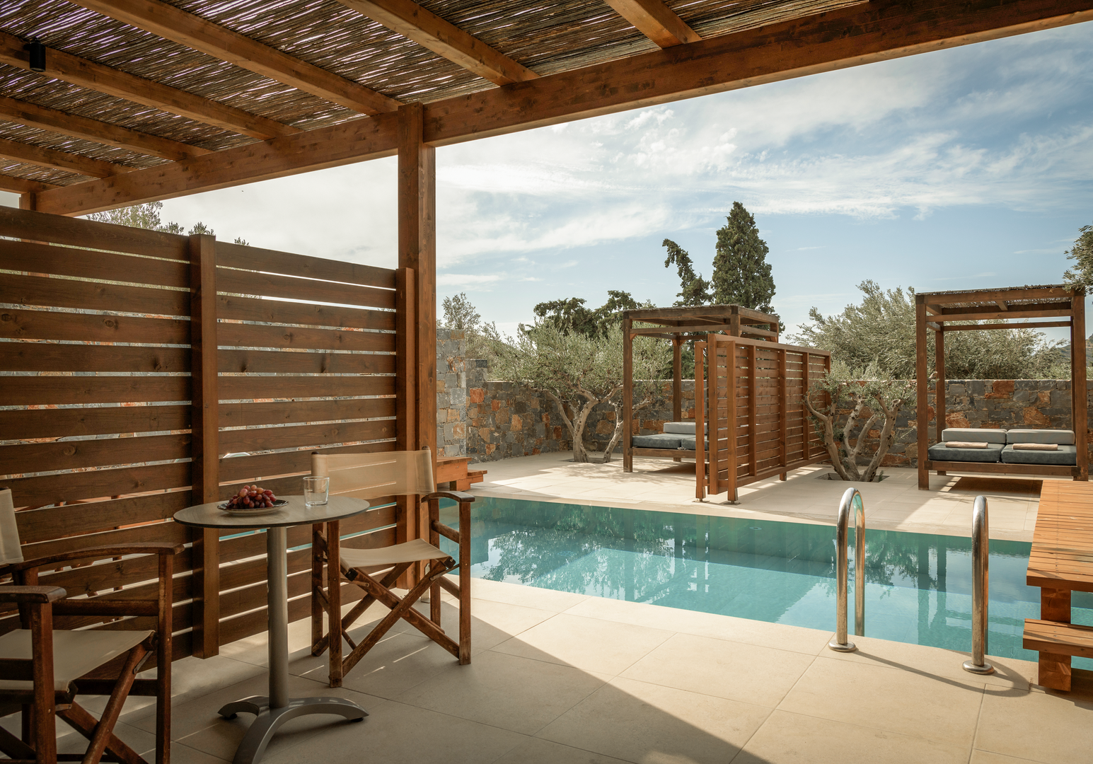 Überdachter Poolbereich mit Liegestühlen und Holzpergola