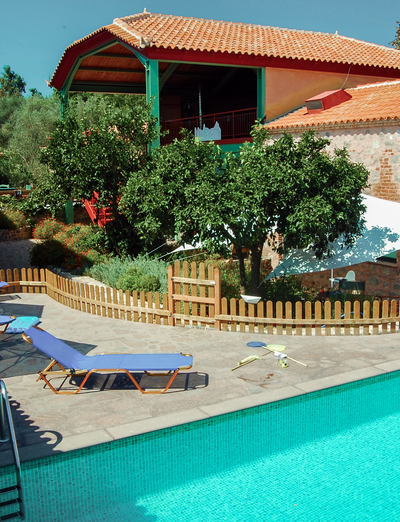 Poolbereich mit Liegen und mediterranen Gebäuden im Hintergrund.