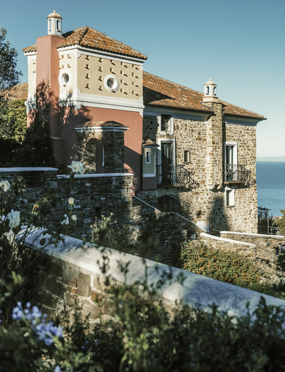 Natursteinhaus in Hanglage mit Blick auf die umliegende Landschaft und das Meer.