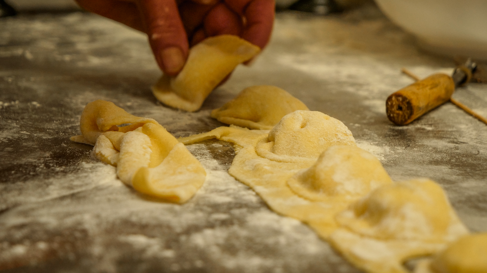Zubereitung von gefüllter Pasta auf einer bemehlten Arbeitsfläche.