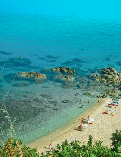 Blick auf eine kleine Badebucht mit türkisblauem Meer