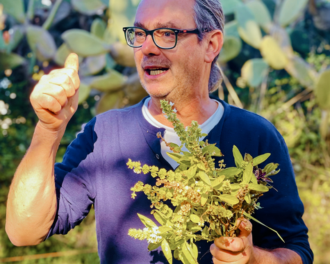 Ein Mann hält frische grüne Pflanzen in seiner Hand 