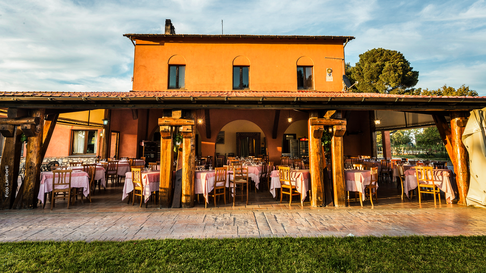 Bestuhlte Terrasse eines Landguts mit überdachtem Sitzbereich.