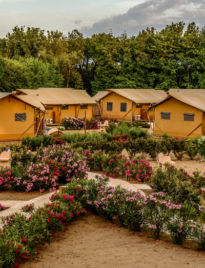 Ferienanlage mit Bungalows, blühenden Gärten und großzügigen Grünflächen.