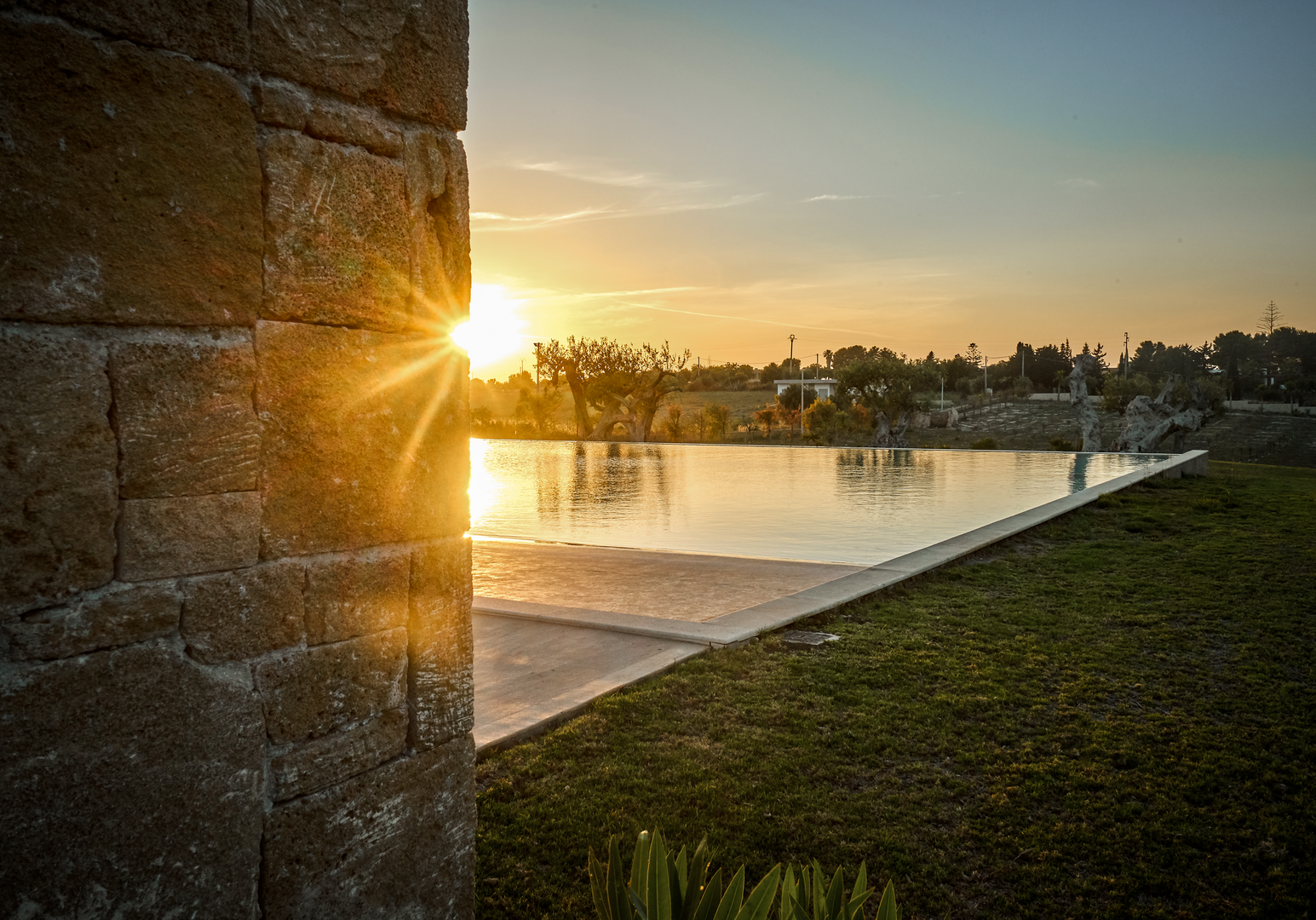 Sonnenuntergang über der Poolanlage einer Ferienunterkunft.
