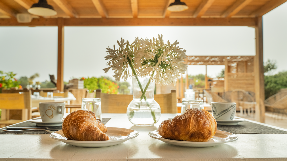 Frühstück auf einer Terrasse mit Blick auf die mediterrane Landschaft.