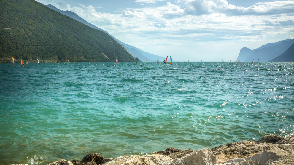 Bergsee mit türkisblauem Wasser vor einer alpinen Kulisse.
