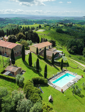 Luftaufnahme eines Landguts mit Pool und umliegender Landschaft.