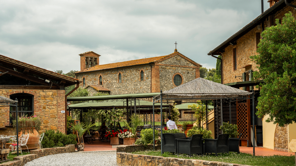 Historischer Innenhof mit Terrasse und Sitzplätzen im Freien.