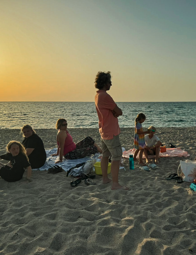 Menschen genießen den Sonnenuntergang am Strand.