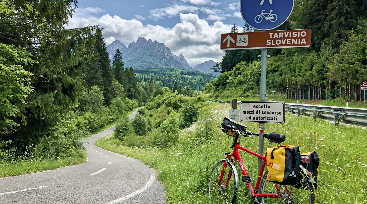 Reiserad an einem Radweg mit Blick auf die Berglandschaft.