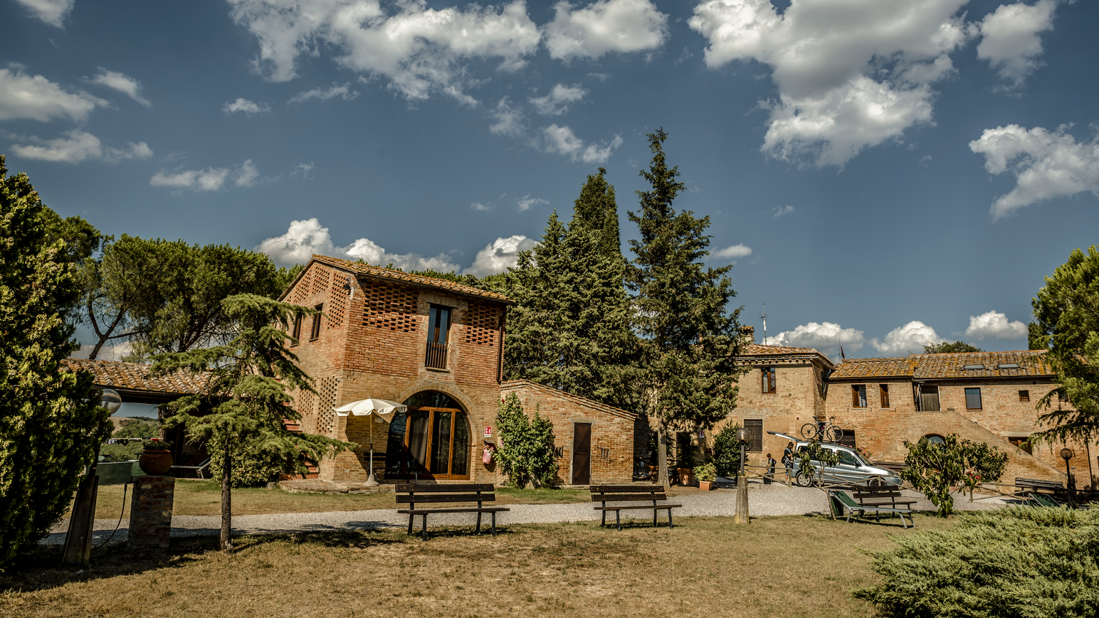 Traditionelles Landhaus mit Innenhof, umgeben von Bäumen und mediterraner Natur.