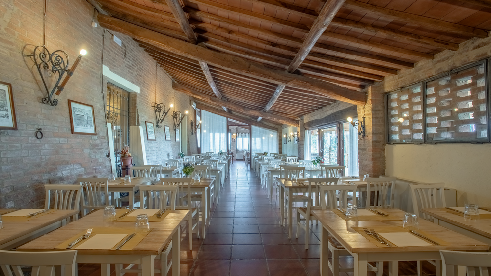 Heller Speisesaal mit Holzbalkendecke und großen Fenstern in einem Landgut.