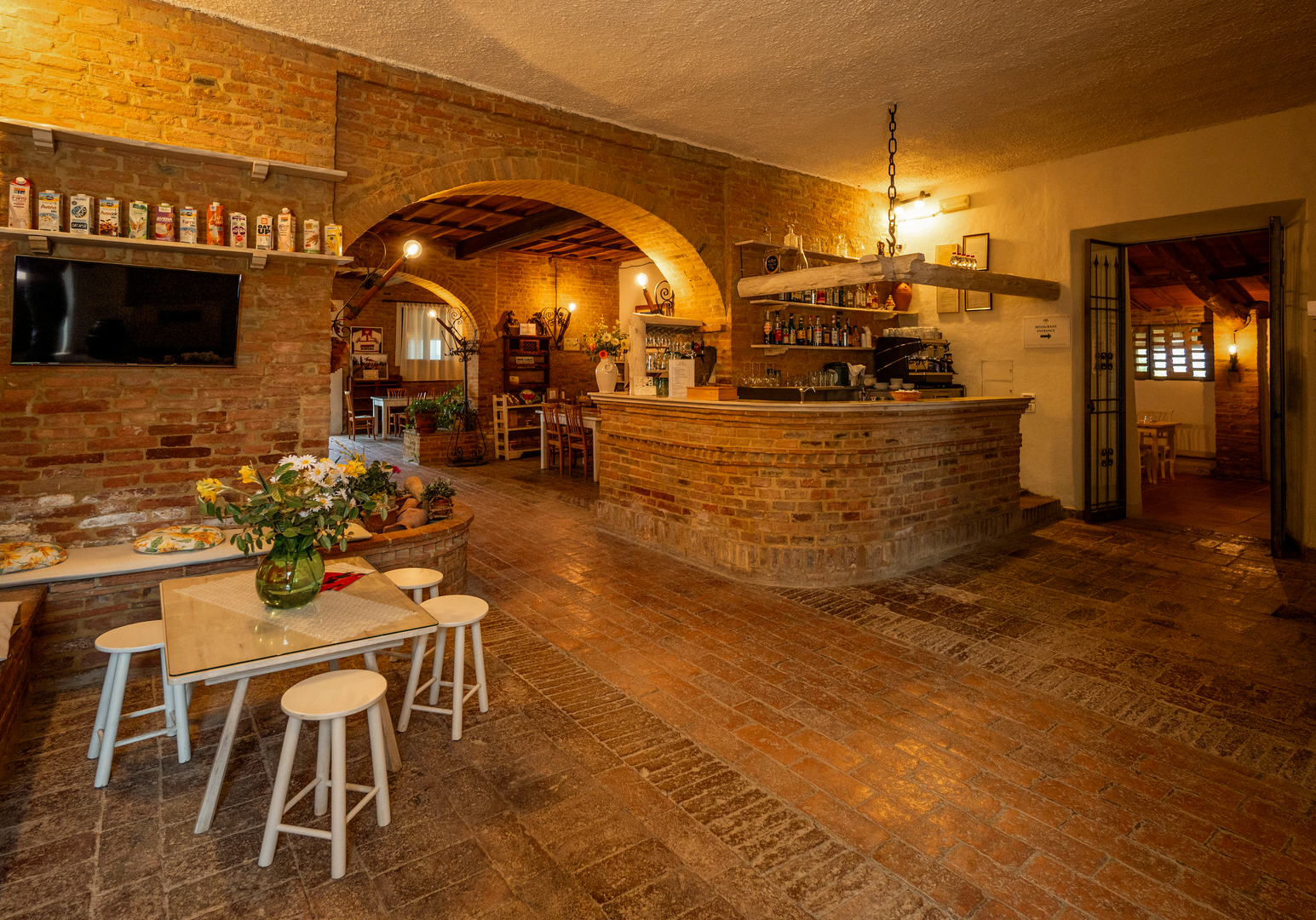 Gemütliches Restaurant mit Natursteinwänden, Holzbalkendecke und rustikalem Ambiente.