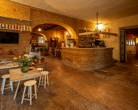 Gemütliches Restaurant mit Natursteinwänden, Holzbalkendecke und rustikalem Ambiente.
