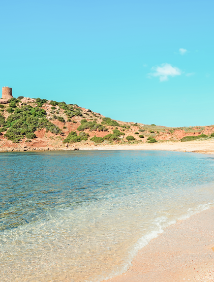 Kleine Insel mit historischem Bauwerk, umgeben von türkisfarbenem Wasser und Sandstrand.