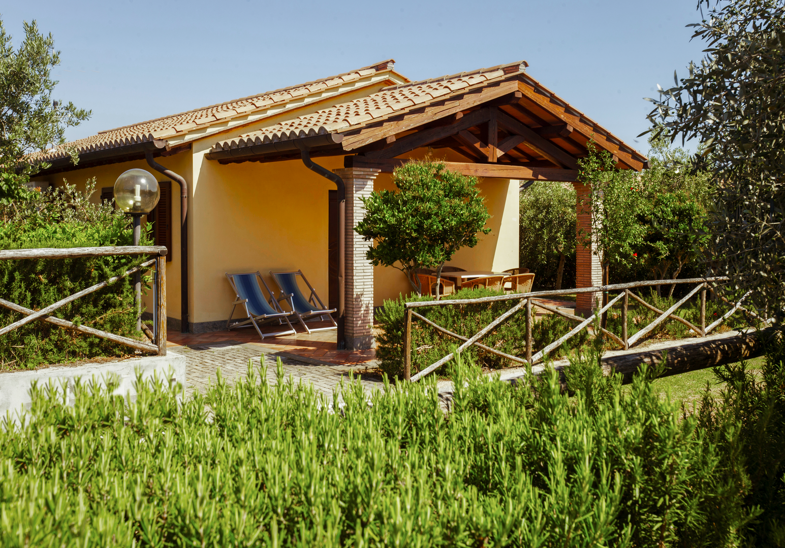 Gemütliches Ferienhaus mit Veranda, umgeben von Lavendel und mediterranen Pflanzen.