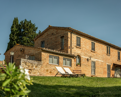 Traditionelles Landhaus mit Terrasse und Liegestühlen, eingebettet in die mediterrane Natur.