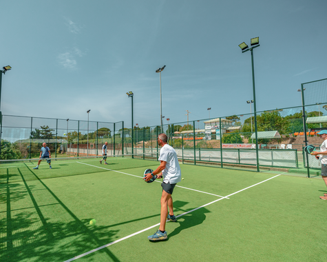 Urlaubsgast spielt Tennis auf einem modernen Außenplatz in einer Sportanlage.