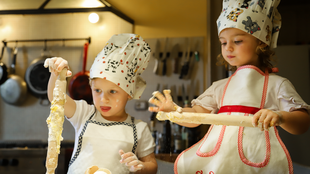 Kinder bereiten gemeinsam Teig zu und lernen spielerisch das Backen.