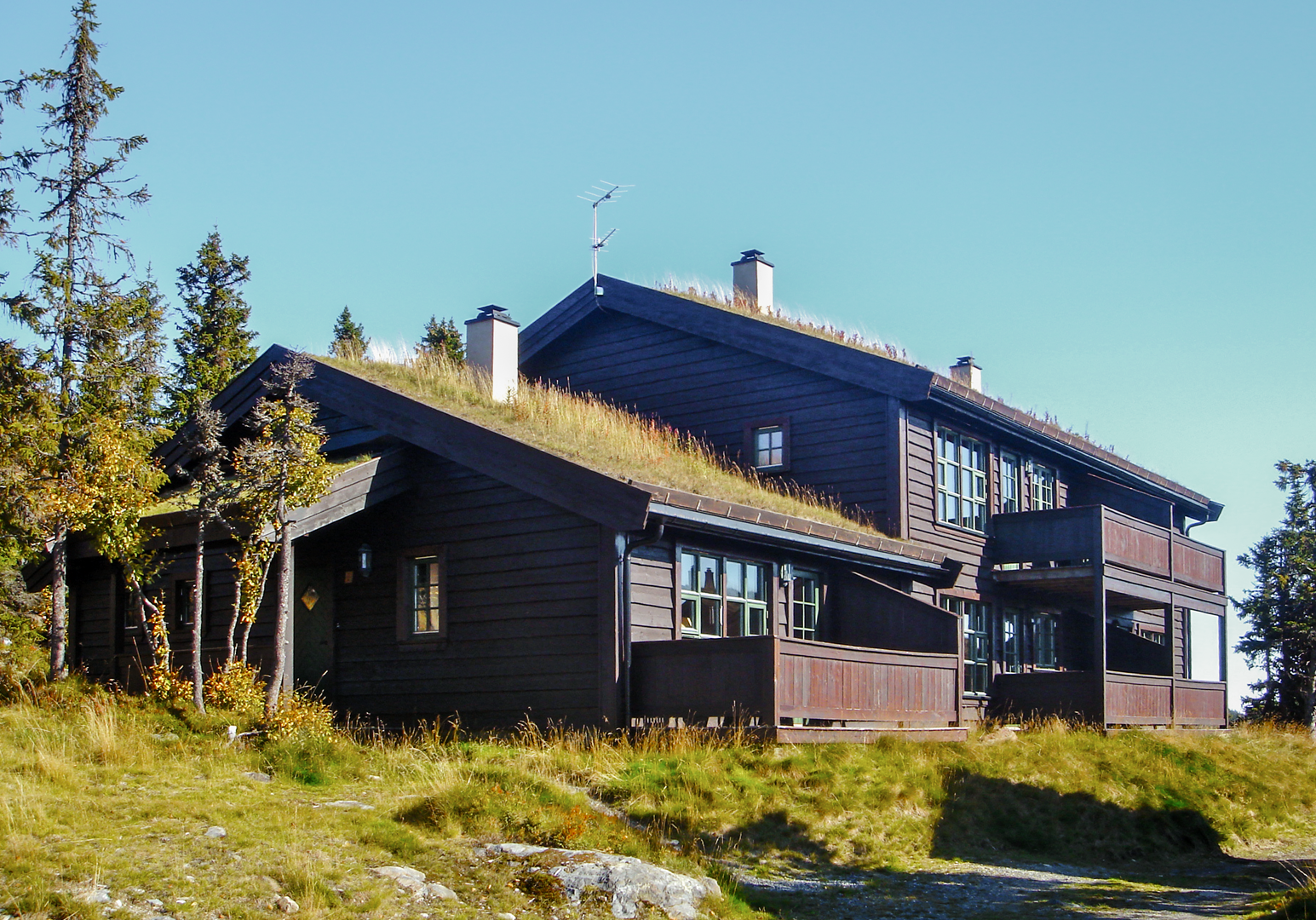 Traditionelles Holzhaus inmitten einer bergigen Landschaft.