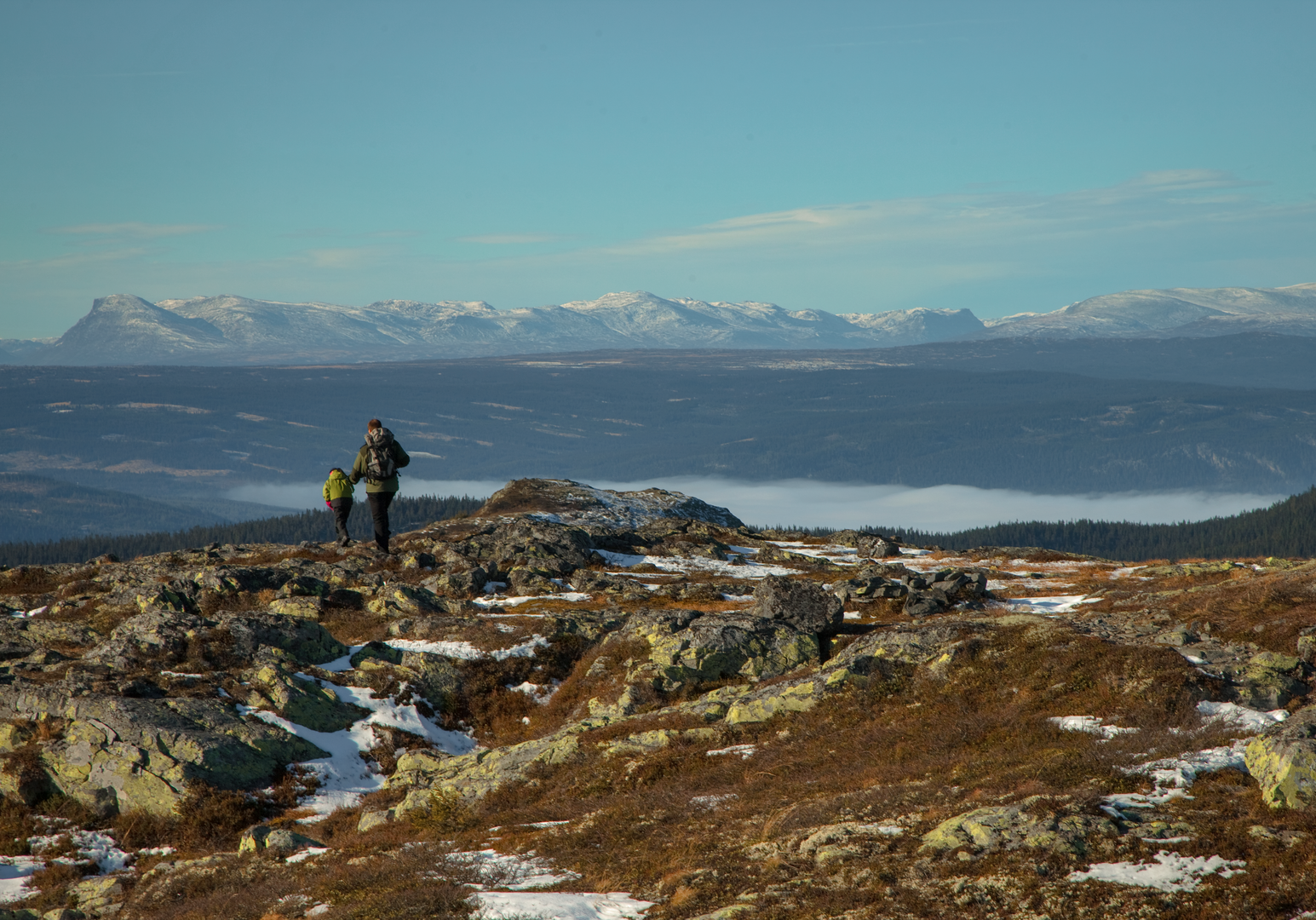 Wandernde auf einem Bergkamm mit weitem Blick über eine offene Hochlandlandschaft.