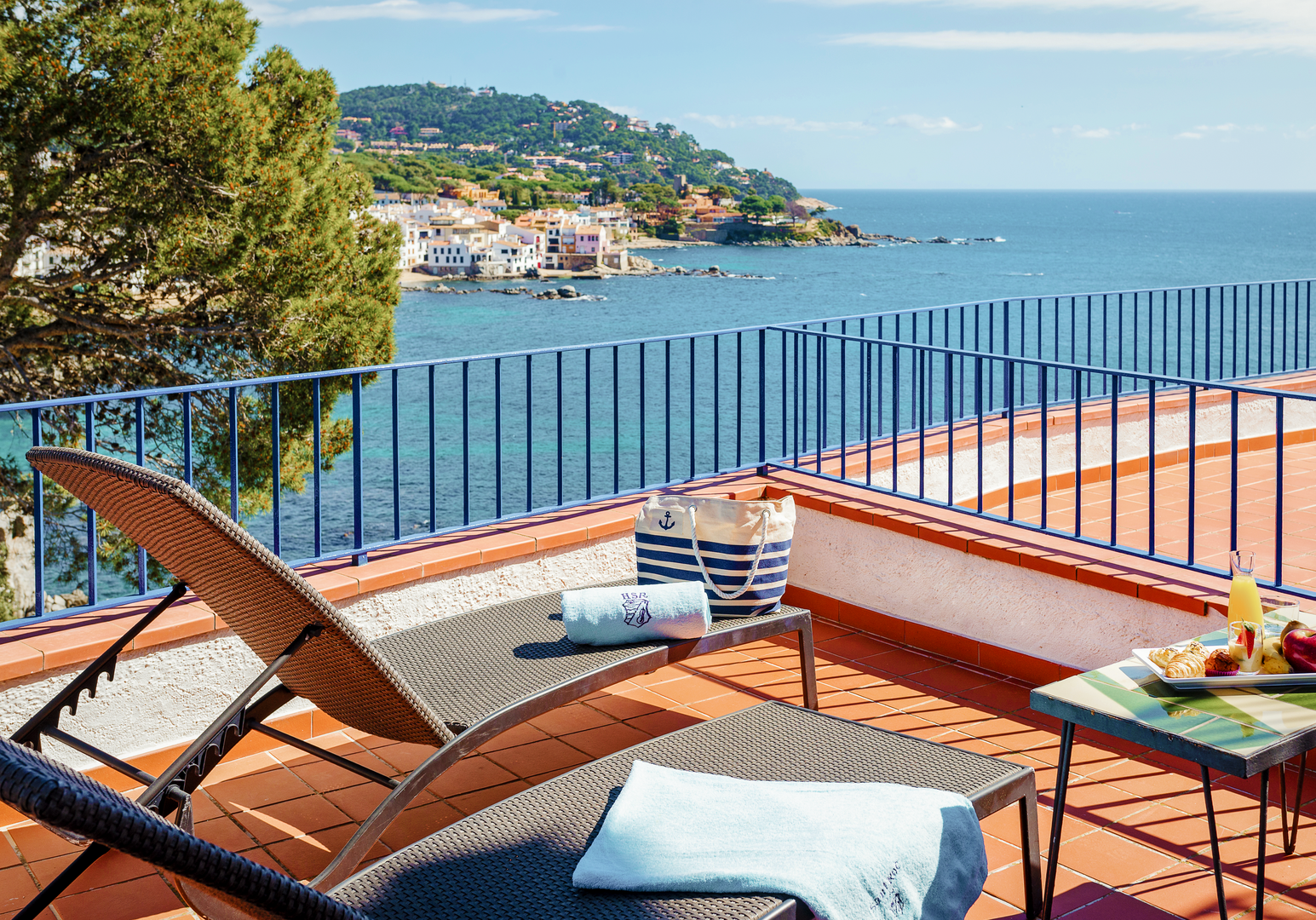 Balkon mit Liegen und Blick auf die Bucht und das Meer