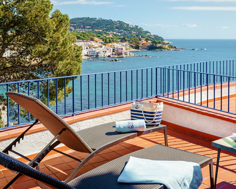 Balkon mit Liegen und Blick auf die Bucht und das Meer