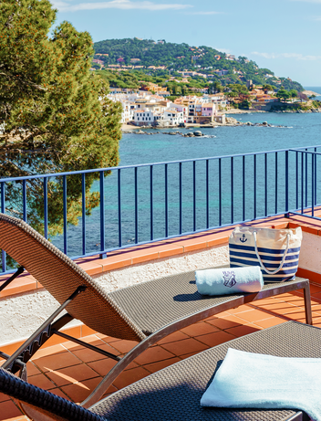Balkon mit Liegen und Blick auf die Bucht und das Meer